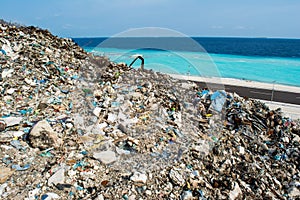 Refuse at the garbage dump near the ocean full of smoke, litter, plastic bottles,rubbish and trash at tropical island