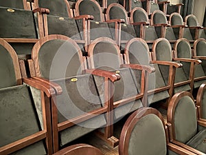 regal ornate rounded wood armed formal empty grey velvet opera or movie or theatre chairs in curved row