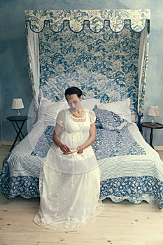 Regency lady sitting on canopy bed