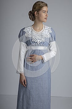 Regency woman in blue striped dress on plain background