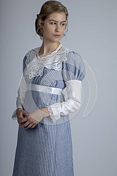 Regency woman in blue striped dress on plain background