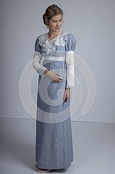 Regency woman in blue striped dress on plain background