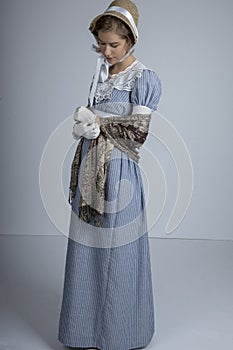 Regency woman in blue striped dress on plain background