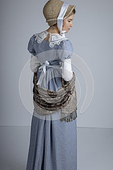 Regency woman in blue striped dress on plain background