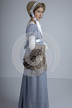 Regency woman in blue striped dress on plain background