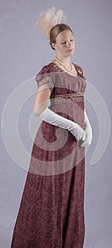 Regency woman in a red dress on studio backdrop