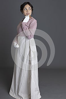 A Regency woman wearing a printed cotton dress and a pink linen short spencer and a pink linen short spencer