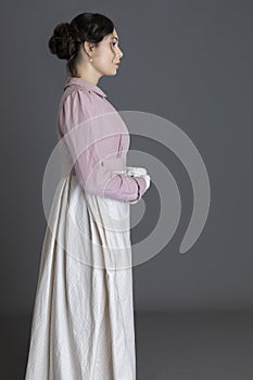 A Regency woman wearing a printed cotton dress and a pink linen short spencer and a pink linen short spencer