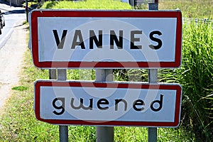 Road sign indicating the entrance to the city of Vannes in French and Breton photo