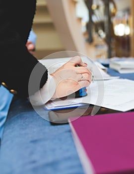 Registration desk table, process of checking in on a conference congress forum event, visitors and attendees receiving a name