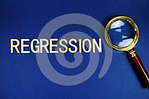 Regression alphabet letters with magnifying glass on navy blue background photo