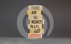 Regrets or lessons symbol. Concept words There are no regrets in life just lessons on wooden blocks on a beautiful grey table grey