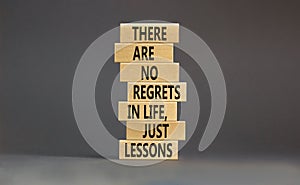 Regrets or lessons symbol. Concept words There are no regrets in life just lessons on wooden blocks on a beautiful grey table grey