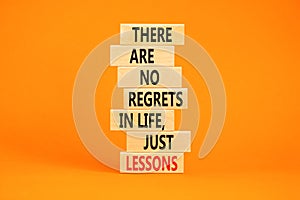 Regrets or lessons symbol. Concept words There are no regrets in life just lessons on wooden blocks on a beautiful orange table