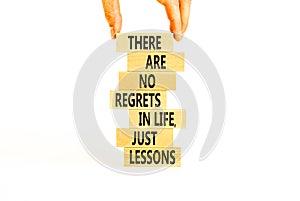 Regrets or lessons symbol. Concept words There are no regrets in life just lessons on wooden blocks on a beautiful white