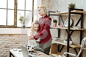 Regretting adult woman in red jacket hugging her offended daughter photo