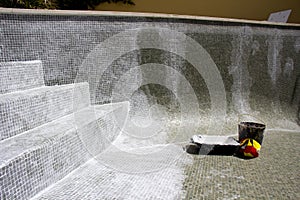 Regrouting in progress on a leaky swimming pool.