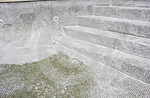 Regrouting in progress on a leaky swimming pool.