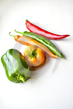 Regular and capsicum yellow and green pepper on a white background