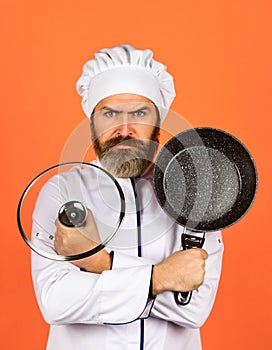 Regular cooking. Preparing food in kitchen. Cooking food concept. High quality frying pan. Bearded man cook white