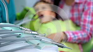 Regular oral cavity checkup in modern pediatric dentistry clinic, handpiece