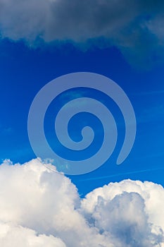 Regular spring clouds on blue sky at daylight in continental europe. Close shot wit telehoto lens and polarizing filter.