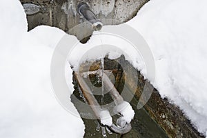 Regulated natural spring or source of water arranged into a fountain in winter captured in high angle view.