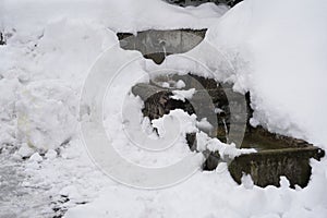 Regulated natural spring or source of water arranged into a small cascade fountain in winter.