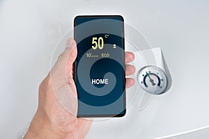 Close up of a person hand adjusting temperature on thermostat th photo
