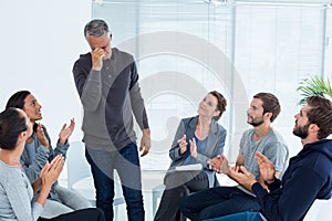 Rehab group applauding delighted man standing up