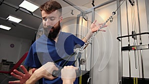 Rehabilitation concept. Young man doing exercises under physiotherapist