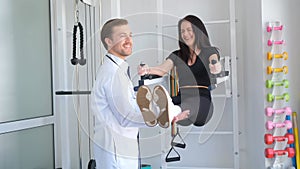 A rehabilitation doctor deals with a female patient. Spine rehabilitator. Orthopaedist