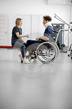 Rehabilitation specialist with guy on a wheelchair doing exercise