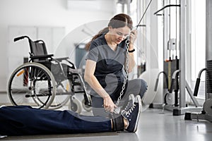 Rehabilitation specialist helps a guy to do exercise on decompression simulator for recovery