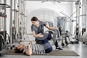 Rehabilitation specialist helps a guy to do exercise on decompression simulator for recovery