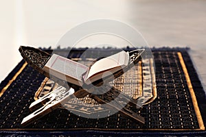 Rehal with open Quran on Muslim prayer mat