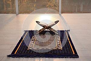 Rehal with open Quran on Muslim prayer rug