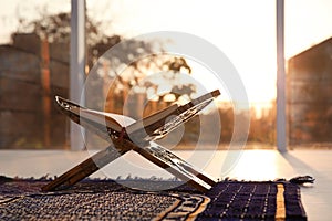 Rehal with open Quran on Muslim prayer rug