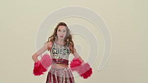 Rehearsal dance of a cheerleader in uniform on a white studio background. The cheerleader dances an uplifting dance