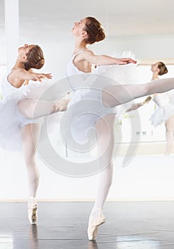 Rehearse, rehearse, rehearse. Full length shot of two ballerinas rehearsing in a studio.