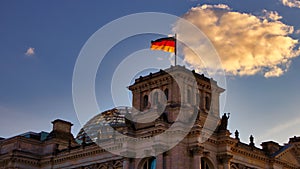 The Reichstag building, seat of the German Bundestag, with a waving flag of the Federal Republic of Germany