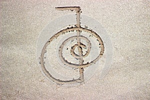 Reiki healing symbol cho ku rei on sand.