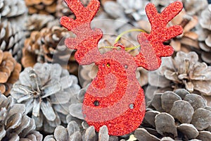 Reindeer head decoration between pinecones.