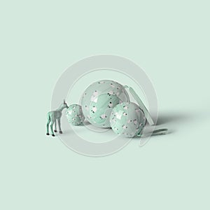 Reindeer standing on Christmas balls, on green mint background. Minimal concept