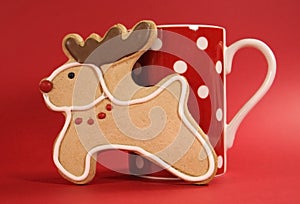 Reindeer vanilla cookie biscuit with red polka dot cup of coffee close up