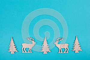 Reindeers, christmas trees, blue colored background, copy space for text, greeting card