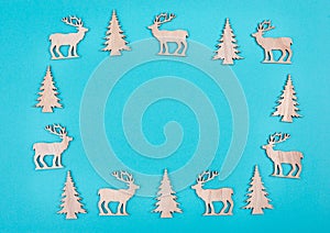 Reindeers, christmas trees, blue colored background, copy space for text, greeting card