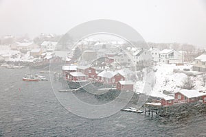 Reine fishing village on Lofoten islands with red rorbu houses in winter with snow. Lofoten islands, Norway, Europe