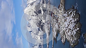 Reine Village and Mountains in Winter. Lofoten Islands, Norway. Aerial View. Vertical Video