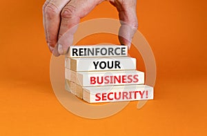 Reinforce your business security symbol. Concept word Reinforce your business security on blocks. Beautiful orange background.